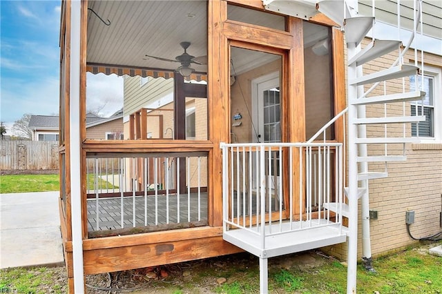 wooden terrace featuring fence and a ceiling fan