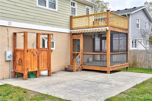 rear view of house with fence, a patio area, and a sunroom