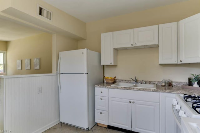 903 Bethel Rd, Chesapeake, VA 23324 - kitchen with white appliances, a sink, white cabinets, light tile patterned floors, and wainscoting