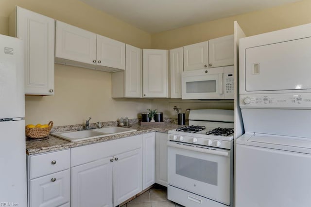 903 Bethel Rd, Chesapeake, VA 23324 - kitchen featuring white appliances, stacked washer and clothes dryer, a sink, white cabinets, and light countertops