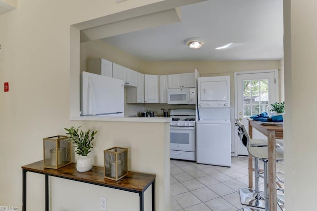 903 Bethel Rd, Chesapeake, VA 23324 - kitchen with white appliances, stacked washing machine and dryer, white cabinets, and light tile patterned flooring