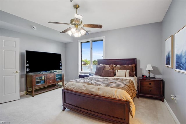 bedroom with light carpet, ceiling fan, and baseboards