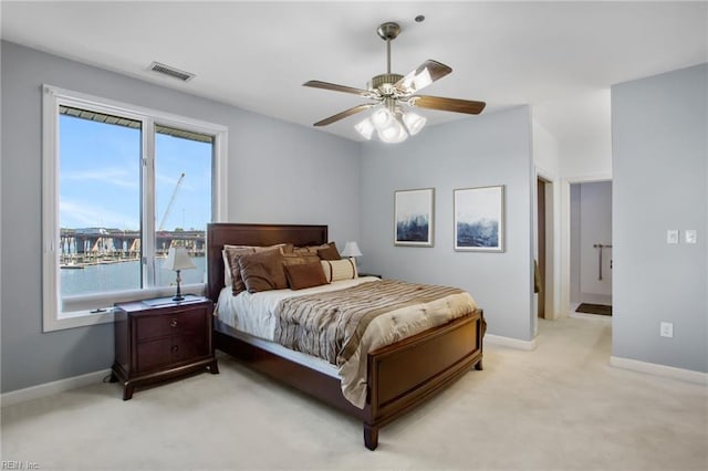 bedroom with light colored carpet, baseboards, and a ceiling fan