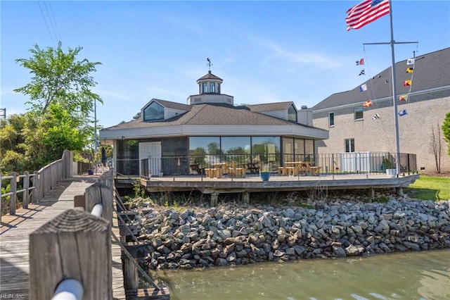 rear view of house with a deck with water view