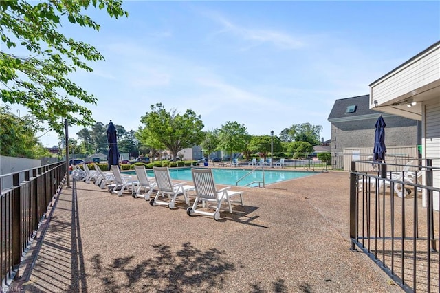 community pool with fence and a patio