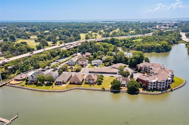 aerial view of residential area with a large body of water and a tree filled landscape