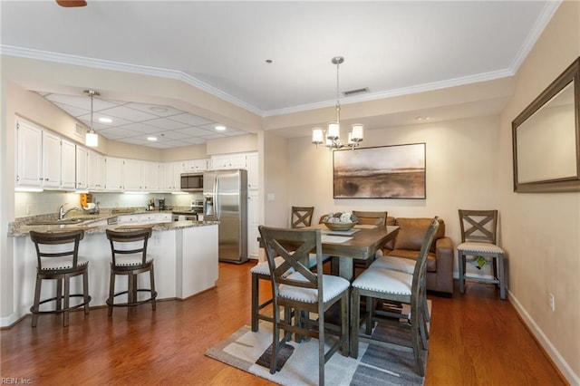 dining room featuring dark wood finished floors, baseboards, a chandelier, recessed lighting, and crown molding