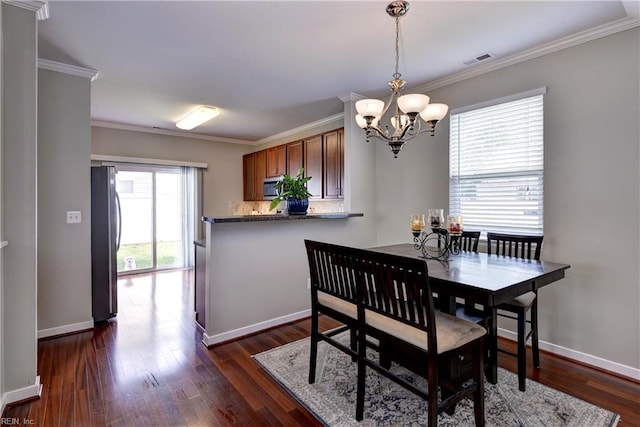 dining area featuring a chandelier, crown molding, dark wood finished floors, and baseboards
