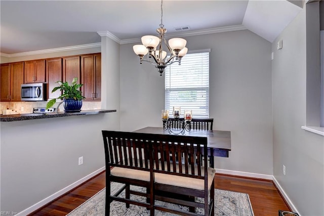 dining space with a chandelier, dark wood-style flooring, ornamental molding, baseboards, and vaulted ceiling