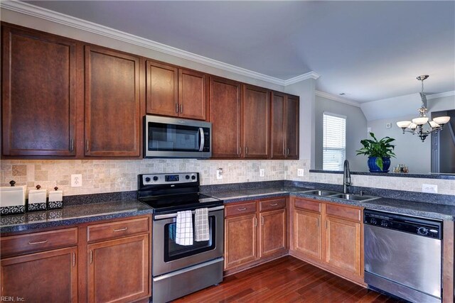 kitchen with stainless steel appliances, a sink, a chandelier, dark wood finished floors, and ornamental molding