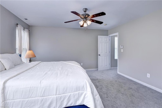 carpeted bedroom featuring multiple windows, baseboards, and ceiling fan
