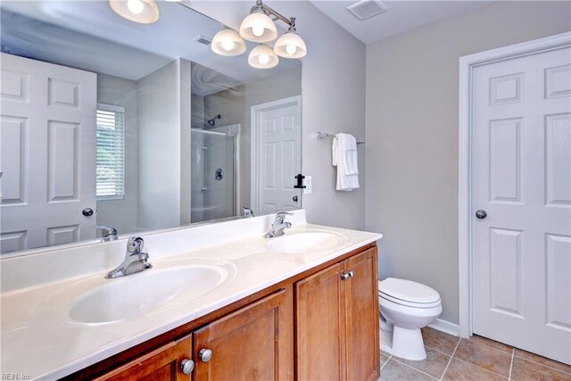 bathroom with tile patterned flooring, a shower stall, double vanity, and toilet