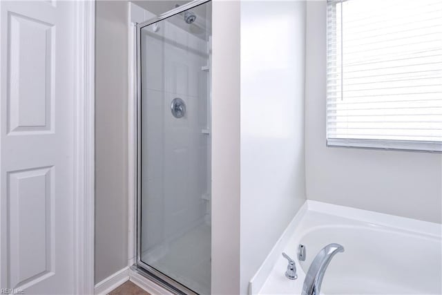 full bath with a stall shower and a bath