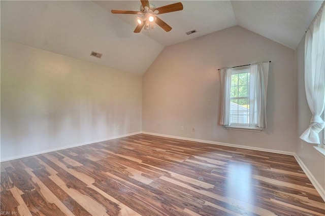 empty room featuring wood finished floors, ceiling fan, lofted ceiling, and baseboards