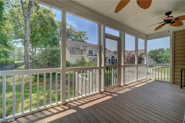unfurnished sunroom with ceiling fan