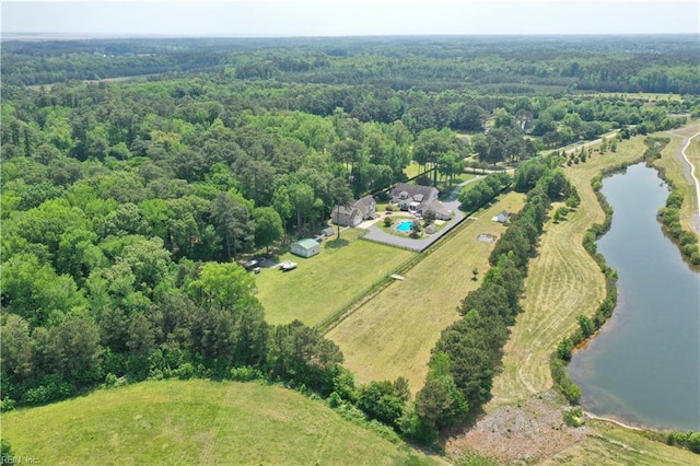 drone / aerial view of a nearby body of water and a heavily wooded area