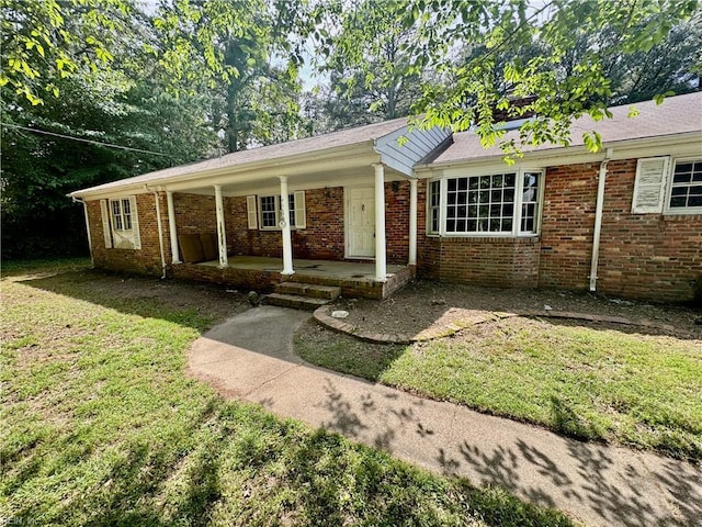 ranch-style house featuring a porch, a front yard, and brick siding