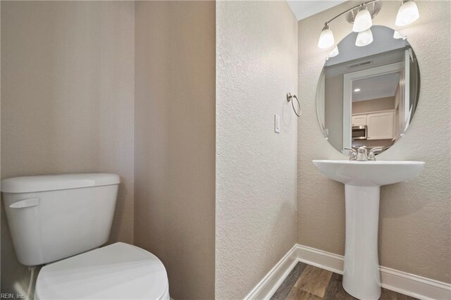 248 Pinner St, Suffolk, VA 23434 - bathroom with wood finished floors, toilet, and baseboards