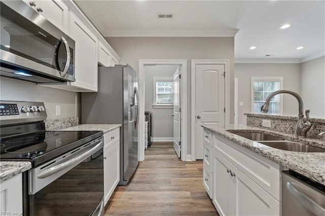 248 Pinner St, Suffolk, VA 23434 - kitchen featuring stainless steel appliances, a sink, crown molding, white cabinets, and light wood-style flooring