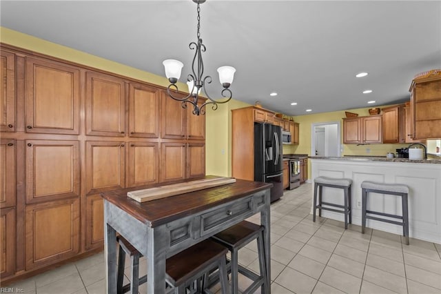 110 Lands End Dr, Elizabeth City, NC 27909 - kitchen featuring stainless steel appliances, light tile patterned flooring, a chandelier, brown cabinetry, and recessed lighting