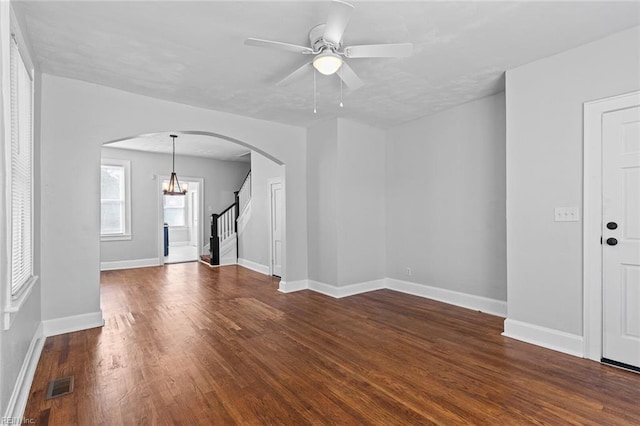 819 Lincoln St, Portsmouth, VA 23704 - unfurnished living room featuring arched walkways, dark wood-style floors, a ceiling fan, stairs, and baseboards