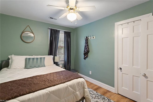 bedroom featuring light wood-style flooring, baseboards, and a ceiling fan