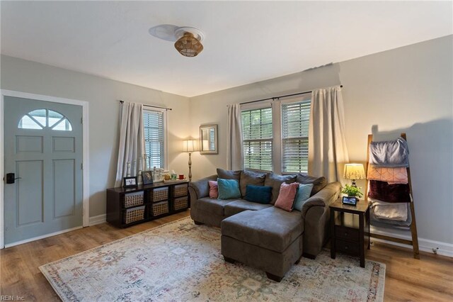 living area featuring healthy amount of natural light, wood finished floors, and baseboards