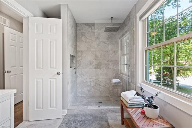 full bath featuring marble finish flooring, a walk in shower, and vanity