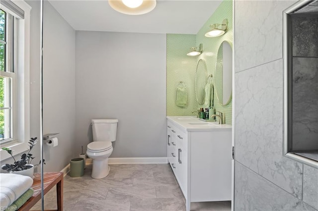 full bathroom with toilet, vanity, and marble look tile flooring