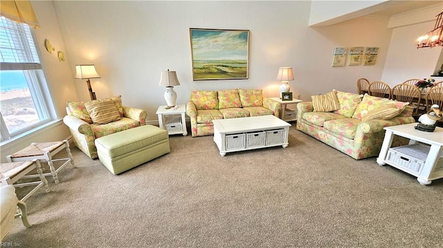living area with carpet floors, plenty of natural light, and a chandelier
