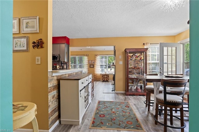 1005 Villas Ct, Virginia Beach, VA 23456 - kitchen with a textured ceiling, stainless steel microwave, wood finished floors, baseboards, and dark countertops