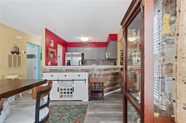 1005 Villas Ct, Virginia Beach, VA 23456 - kitchen featuring stainless steel fridge with ice dispenser, wood finished floors, a textured ceiling, gray cabinets, and tasteful backsplash