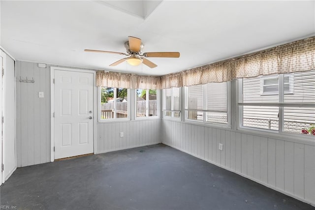 unfurnished sunroom with ceiling fan