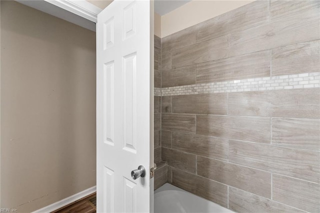 bathroom featuring baseboards and shower / tub combination