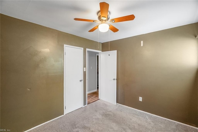unfurnished room with a ceiling fan and carpet flooring