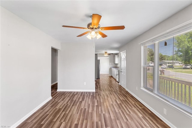 unfurnished living room with a ceiling fan, wood finished floors, and baseboards