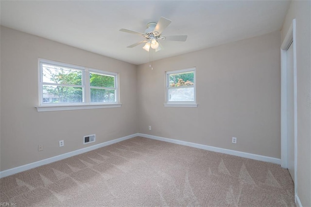 unfurnished room featuring plenty of natural light, carpet, and baseboards