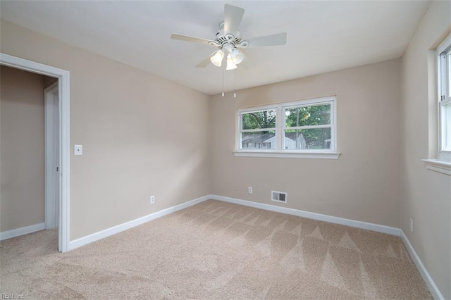 unfurnished room with light carpet, a ceiling fan, and baseboards