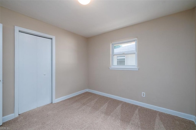 unfurnished bedroom with carpet, baseboards, and a closet