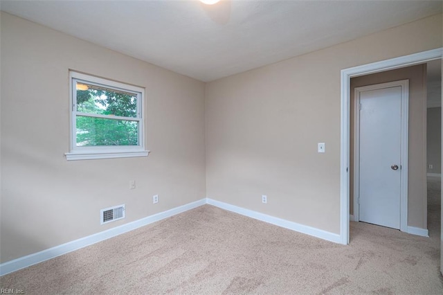 spare room featuring carpet and baseboards