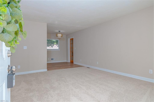 carpeted empty room with baseboards