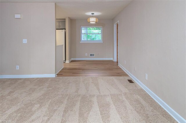 empty room with light colored carpet and baseboards
