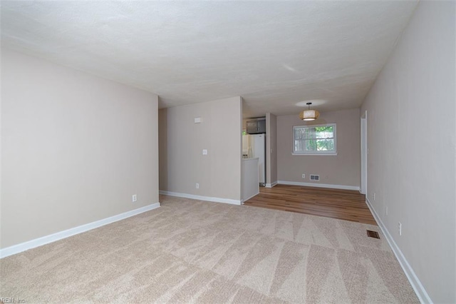 unfurnished room with carpet and baseboards