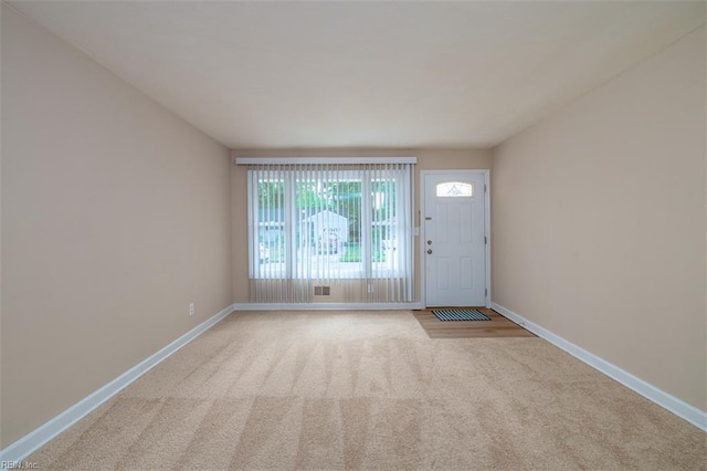 carpeted foyer entrance featuring baseboards