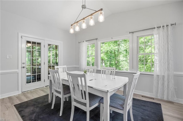 dining room featuring light wood-style floors and lofted ceiling