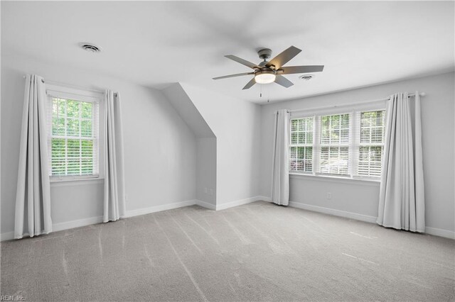 additional living space with plenty of natural light, ceiling fan, baseboards, and carpet