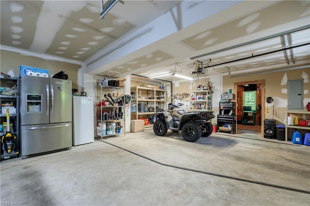 garage featuring stainless steel fridge, electric panel, a garage door opener, and a workshop area