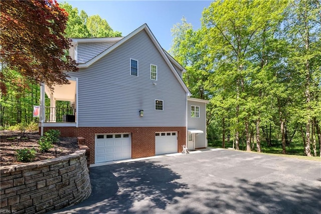 view of property exterior with an attached garage and driveway