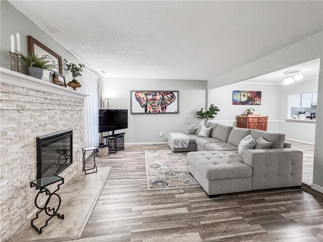 634 Biltmore Dr, Virginia Beach, VA 23454 - living area featuring wood finished floors, a textured ceiling, a stone fireplace, and baseboards