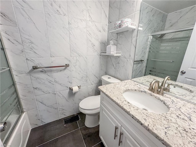 634 Biltmore Dr, Virginia Beach, VA 23454 - bathroom featuring vanity, toilet, tile patterned floors, bath / shower combo with glass door, and tile walls